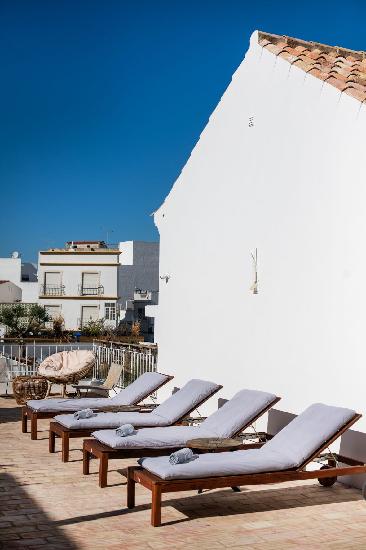 a row of lounge chairs are lined up in front of a white building .