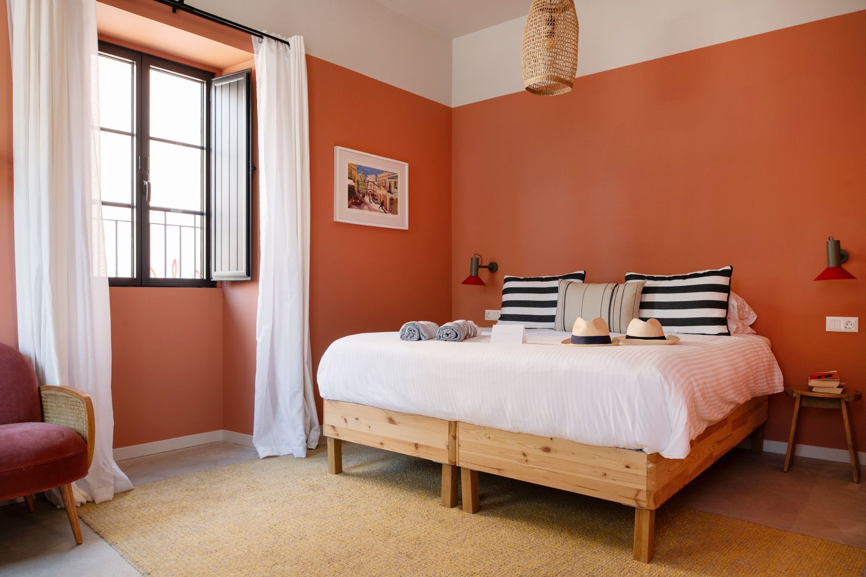 A bedroom with a large bed , a chair , and a window.