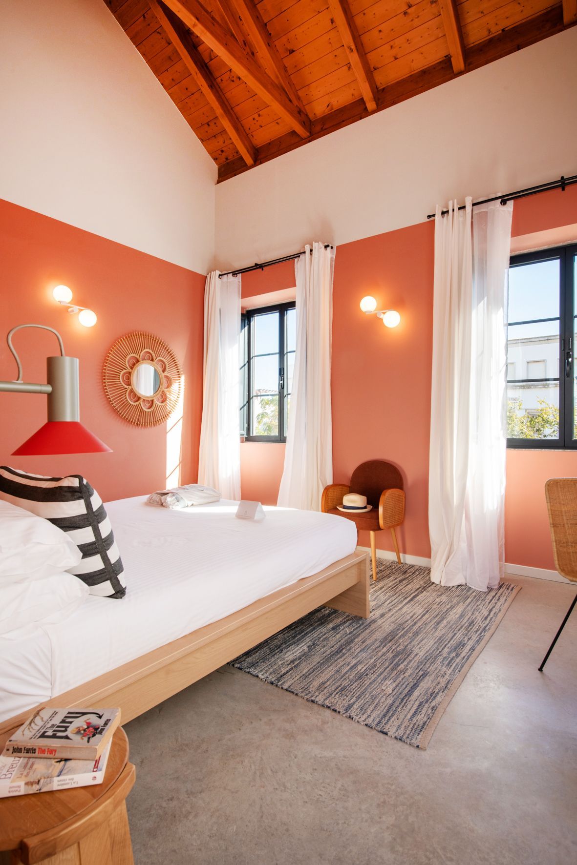A bedroom with a bed , chair , table and window.