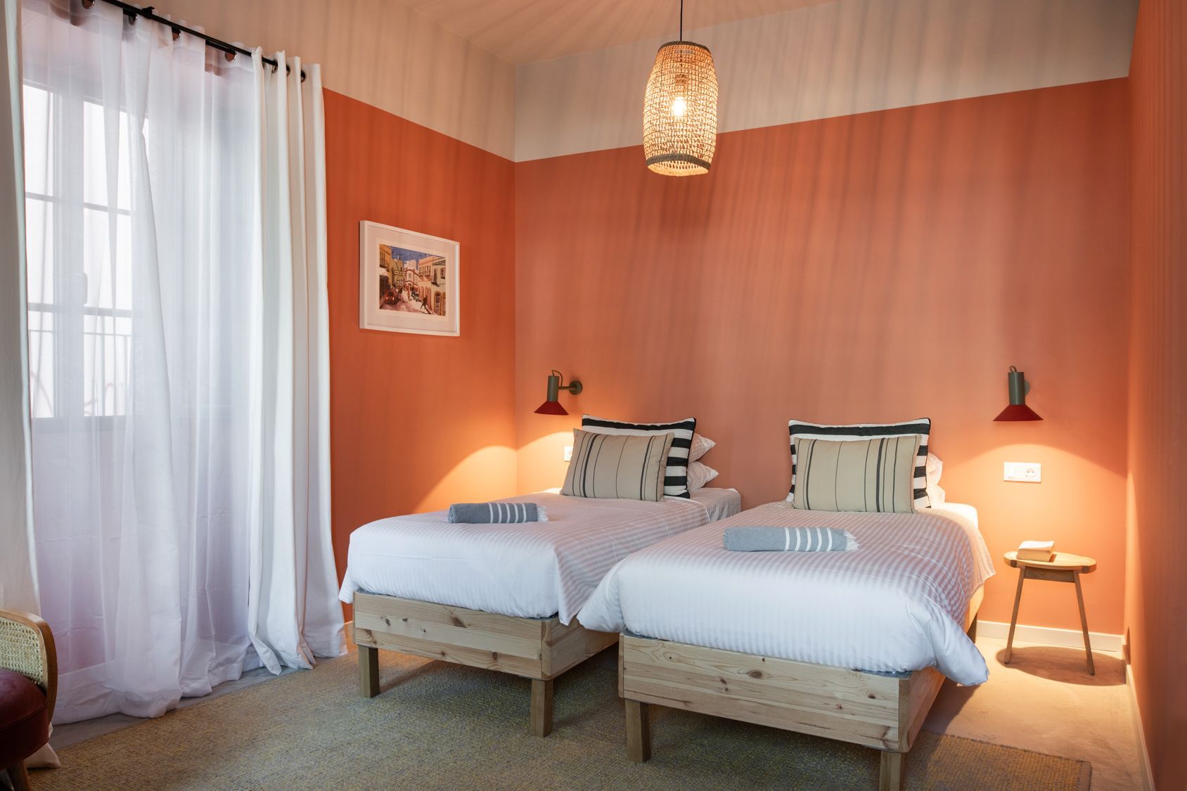 A bedroom with two beds and a window.