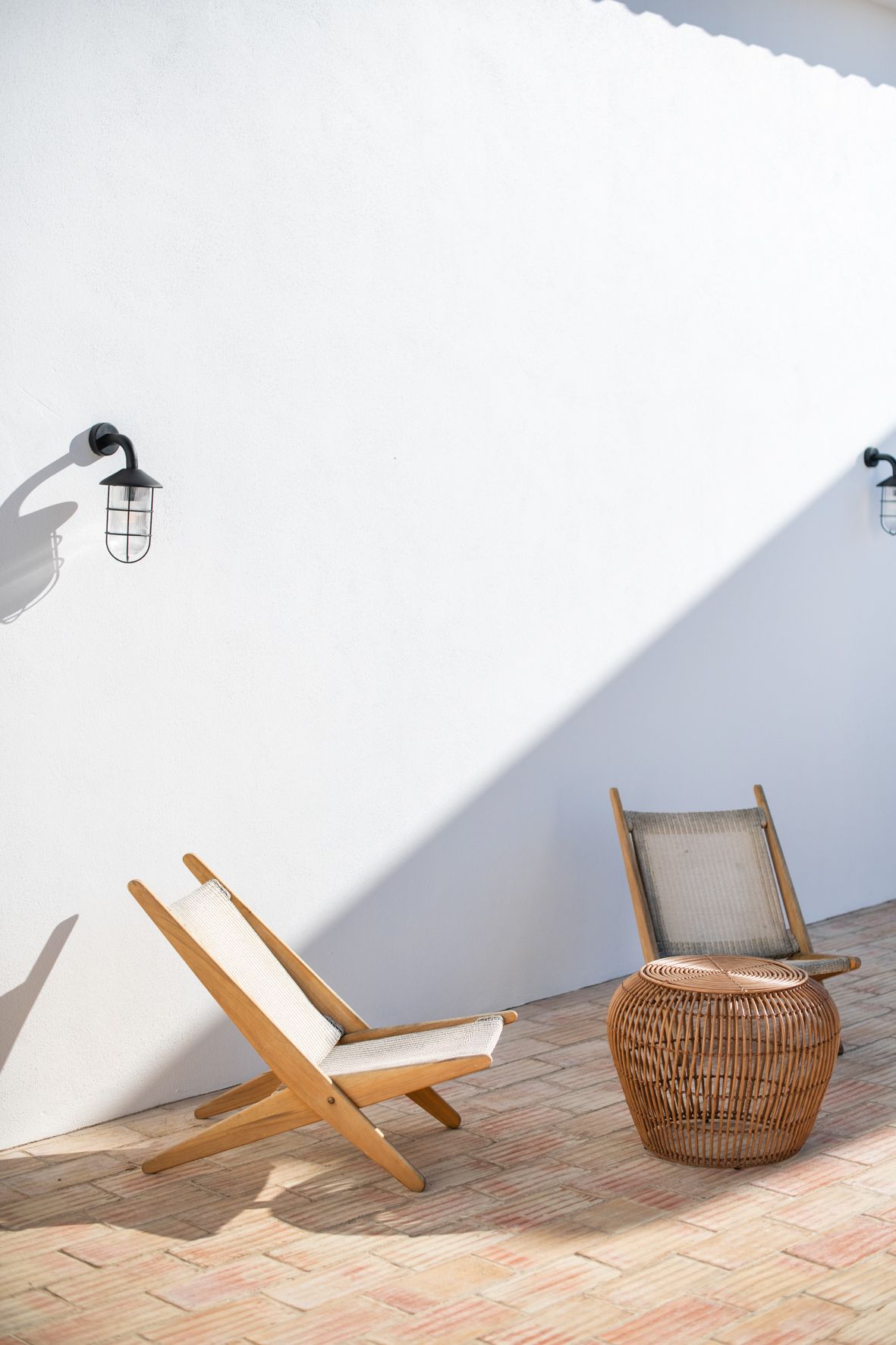 two chairs and a table are sitting in front of a white wall .