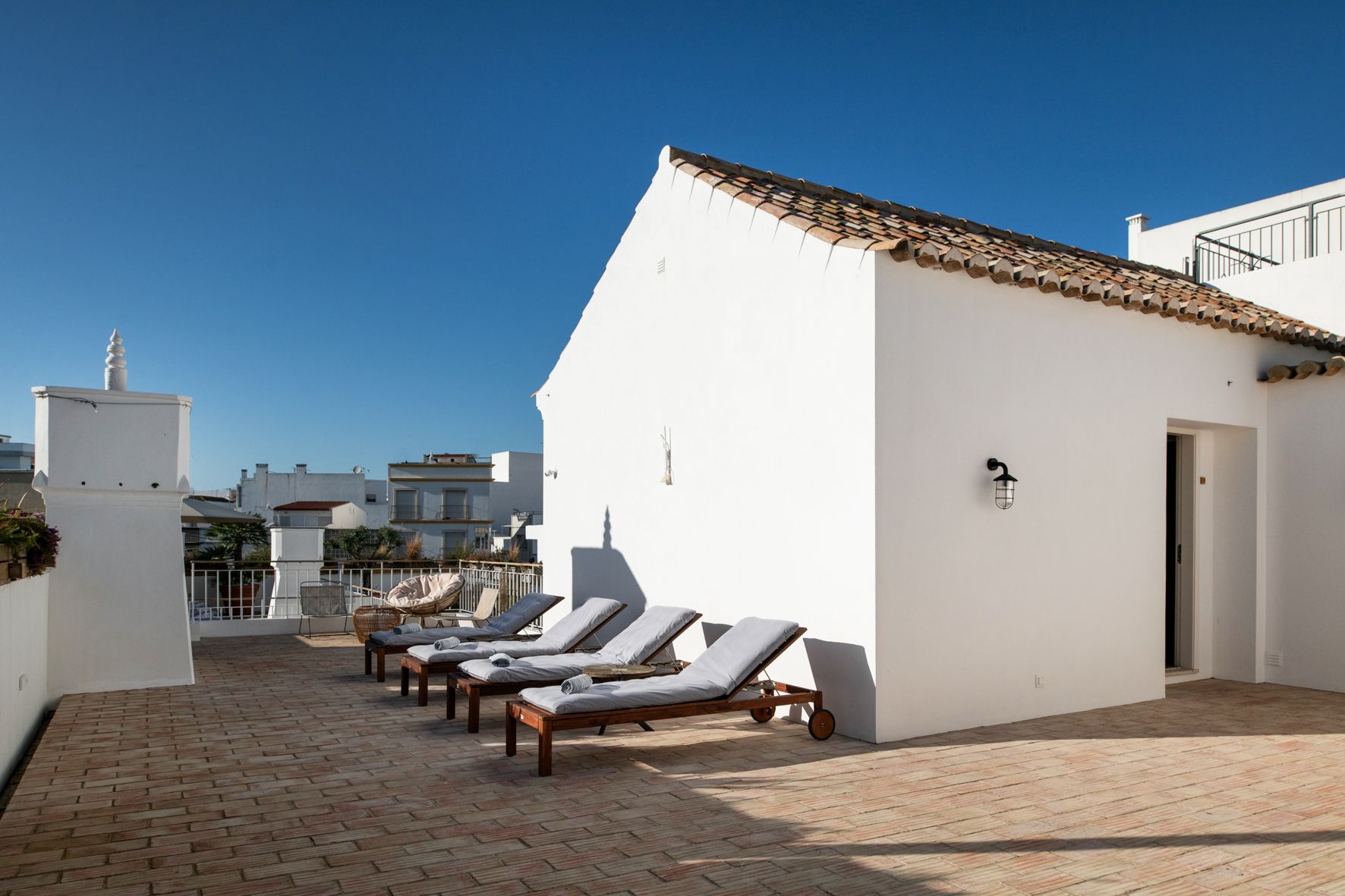 a row of lounge chairs are lined up in front of a white building