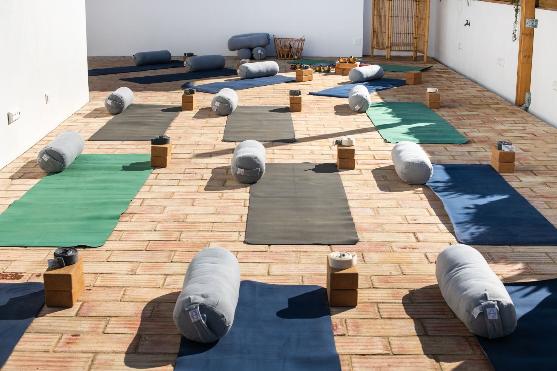There are many yoga mats and pillows on the floor.