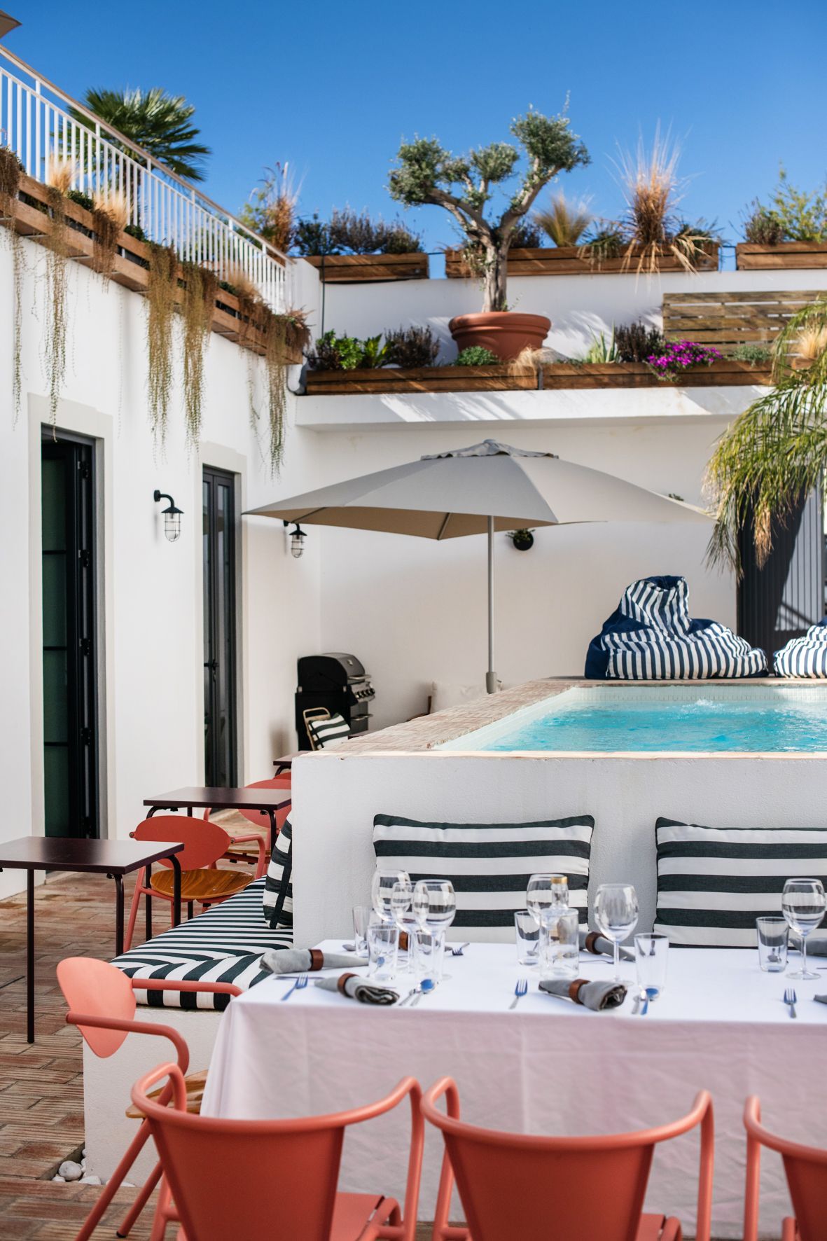 A table and chairs are set in front of a swimming pool.