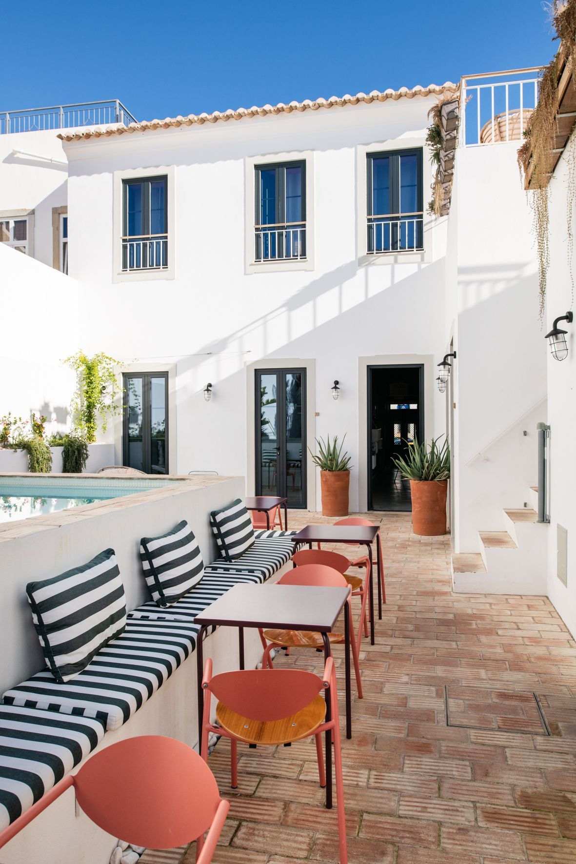 a white building with tables and chairs in front of it