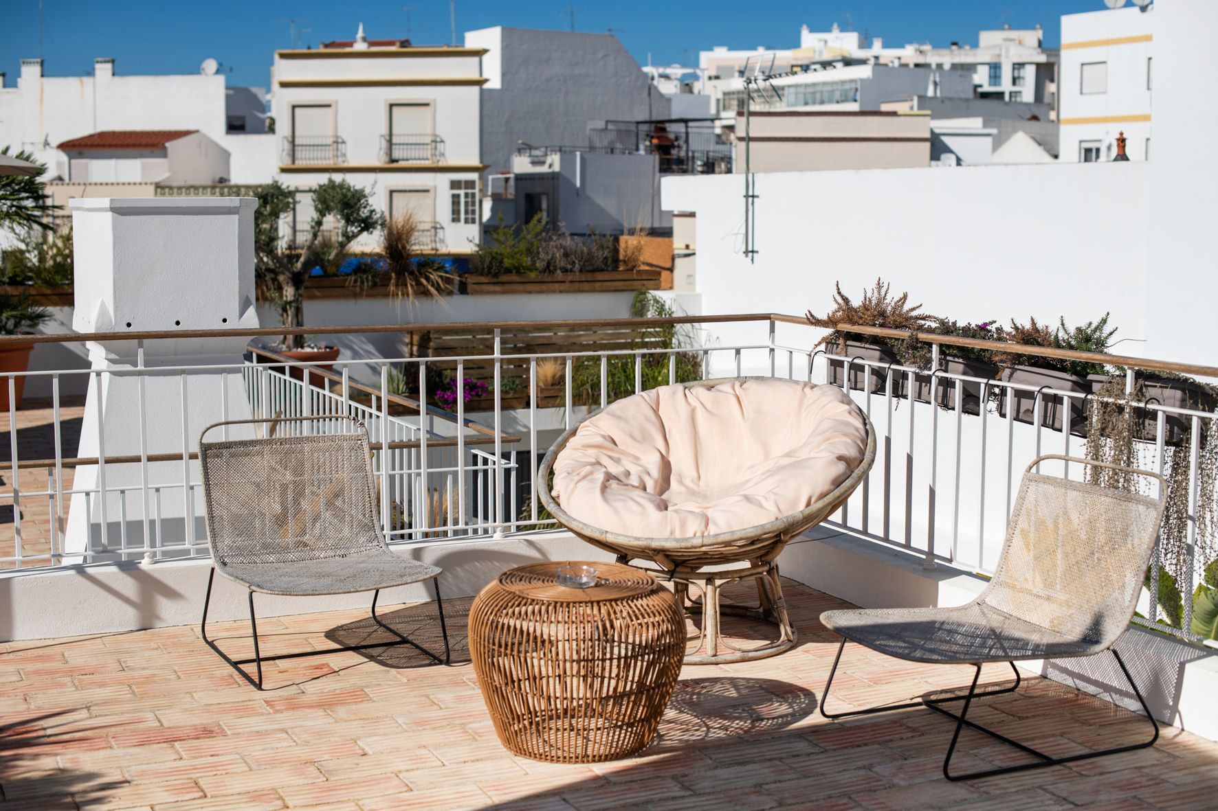 a balcony with chairs and a table with a view of a city .