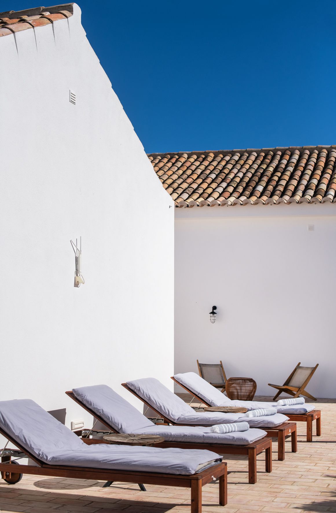 a row of lounge chairs in front of a white building