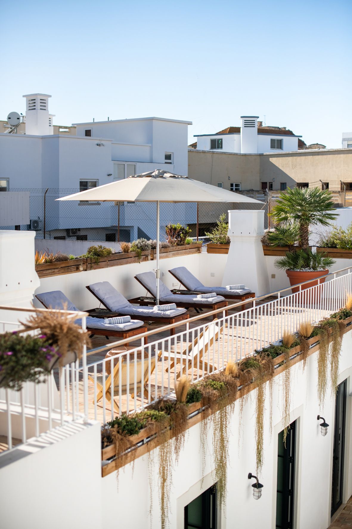 a balcony with umbrellas and lounge chairs on it .