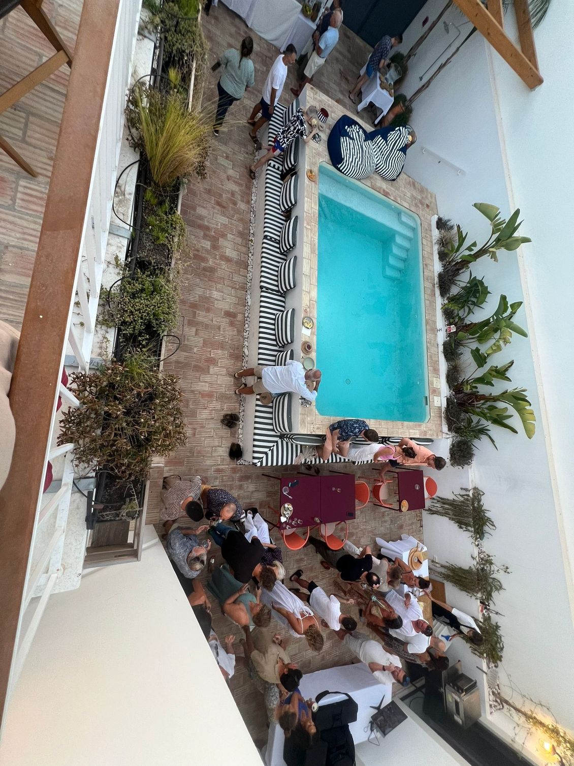 A group of people are gathered around a swimming pool.