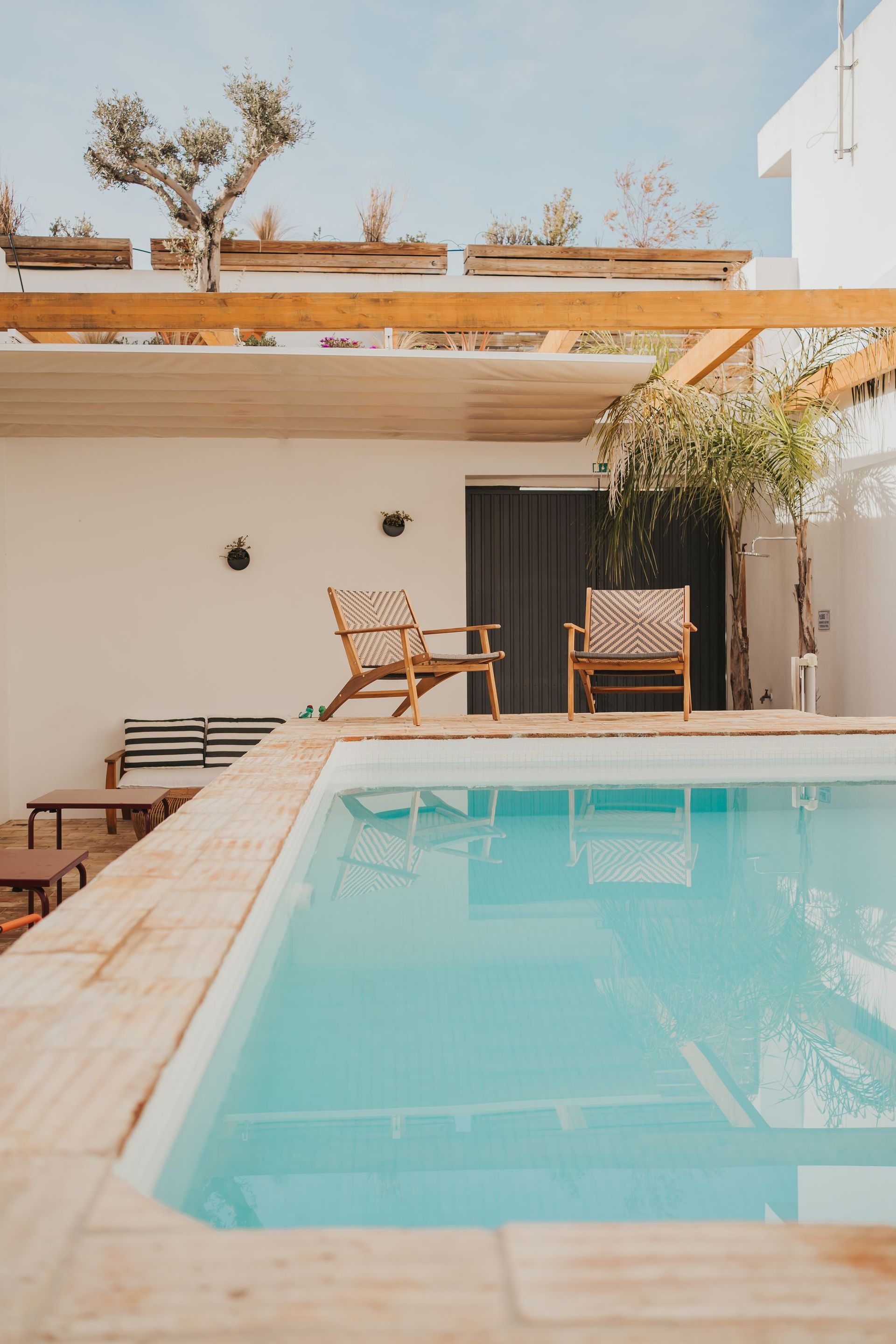 There is a large swimming pool in the backyard of a house.