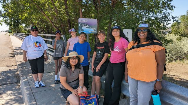 A group of people are standing next to each other on a sidewalk.