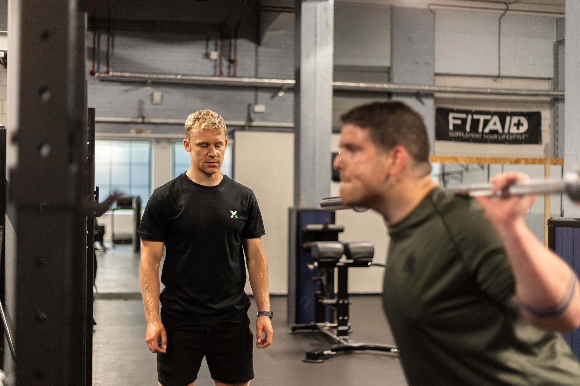 Trainer begeleidt beginner in studio