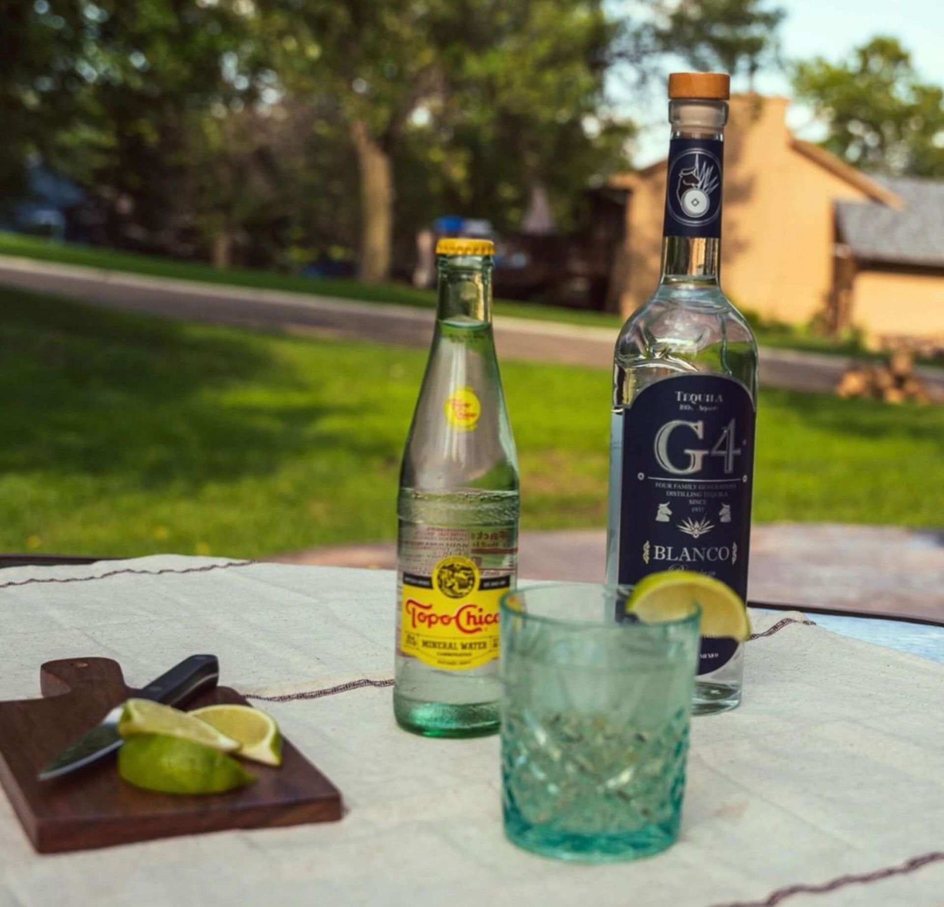 Bottle of Grande Absente absinthe liqueur, green and white label, set on dried herbs.