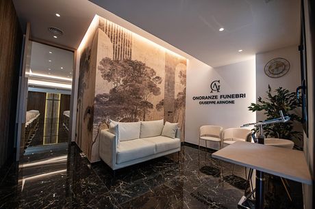 Showroom di mobili moderni con divano bianco, grande murale e illuminazione d'accento calda.