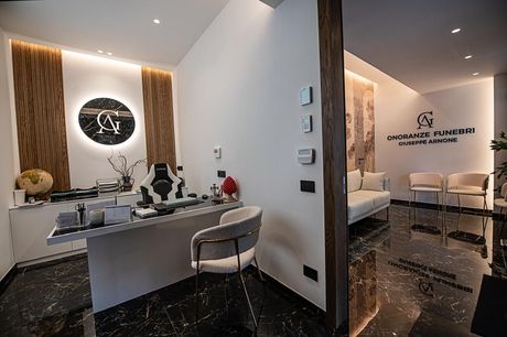 Reception moderna della clinica con pavimenti in marmo nero, pareti bianche e una scrivania affacciata sulla sala d'attesa.