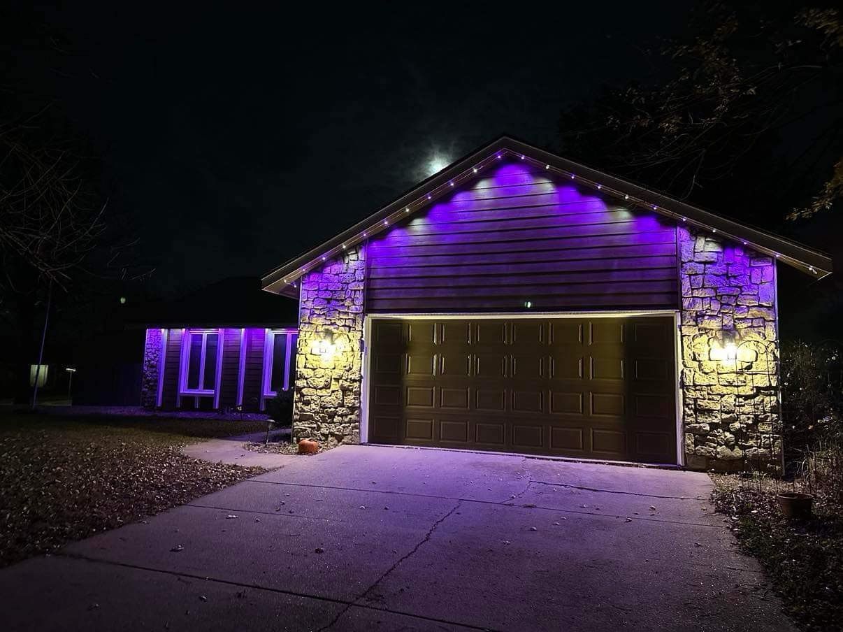 A garage is lit up with purple lights at night.
