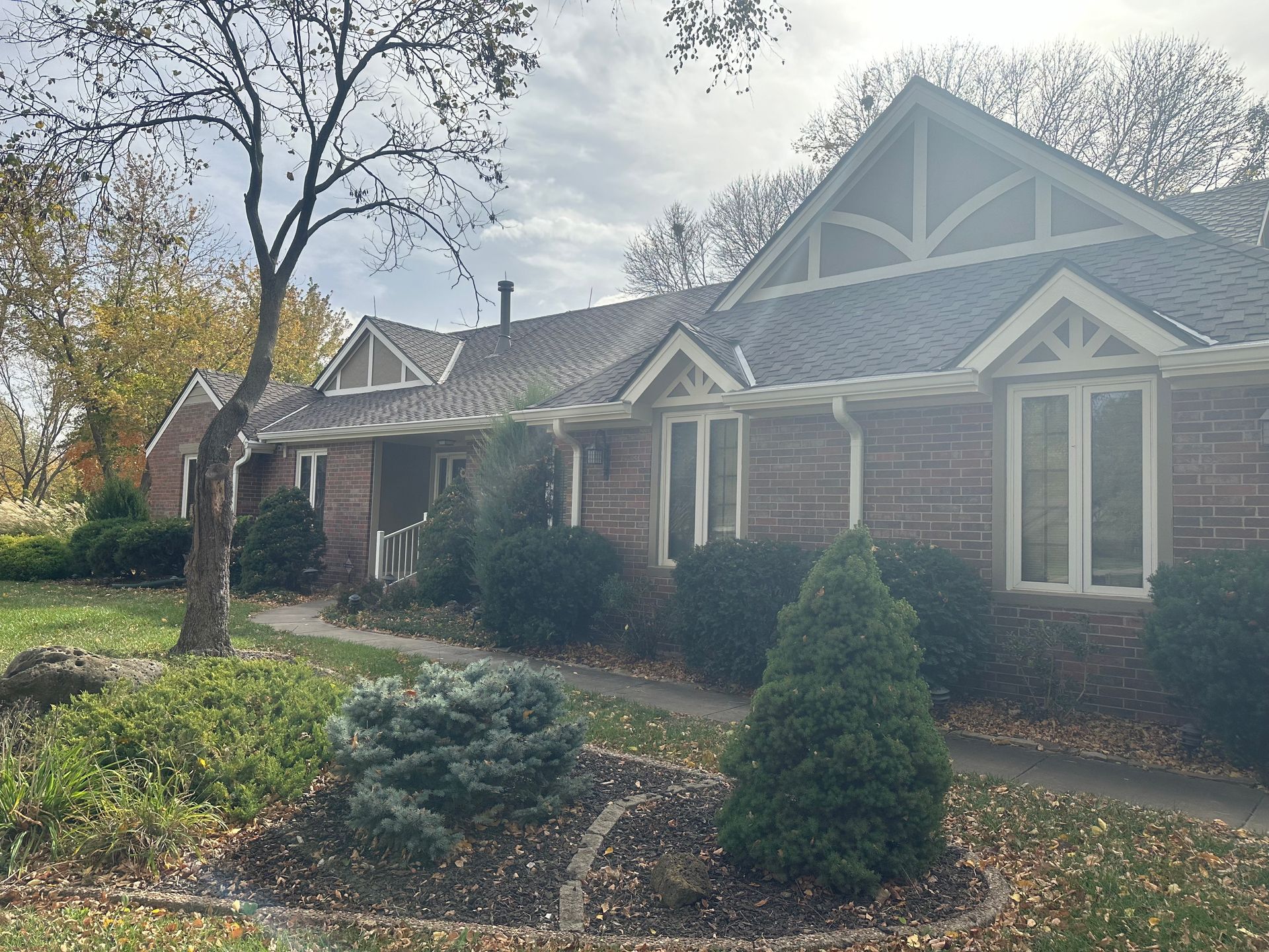 A large brick house with a gray roof and white trim