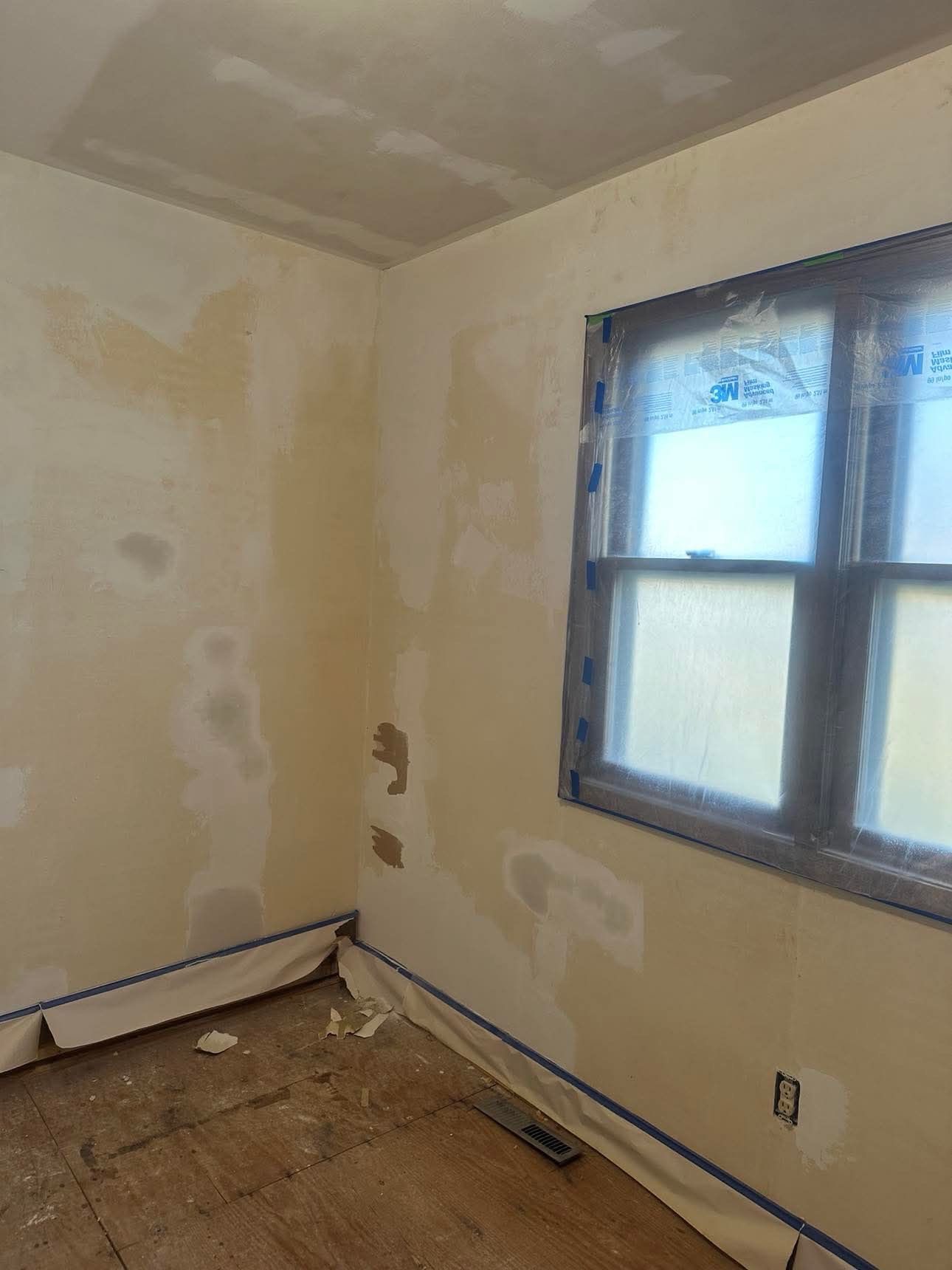 A room with a window and a ceiling that is being painted.