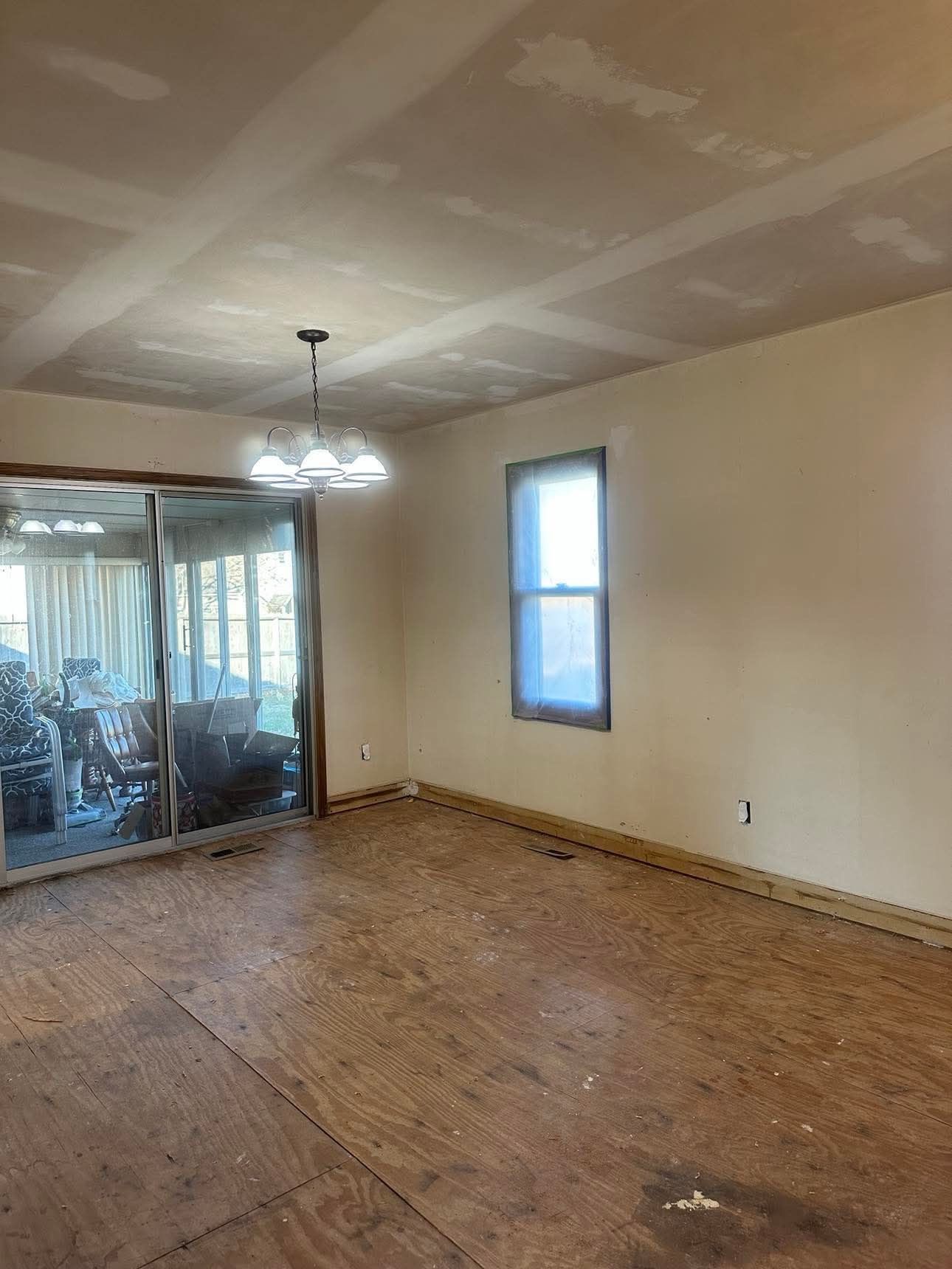 An empty room with a wooden floor and a sliding glass door.