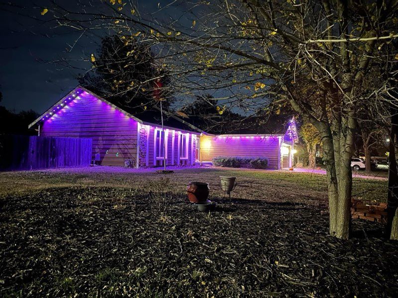 A house with purple lights on it is lit up at night.