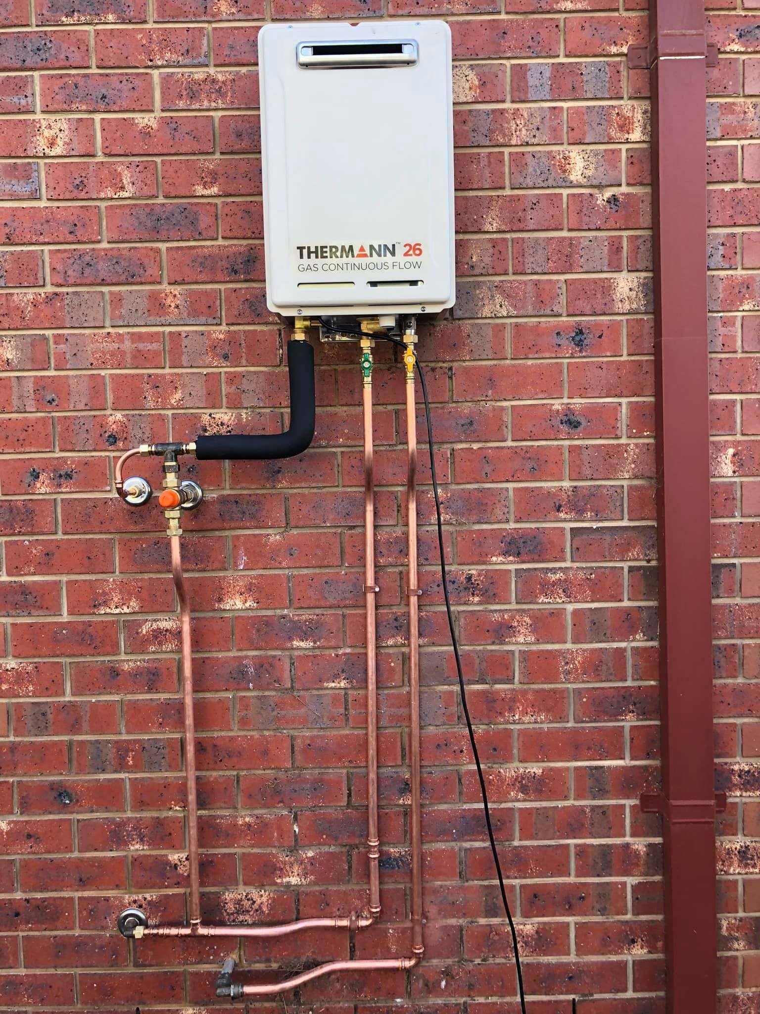 A Wall-mounted, Beige Gas Water Heater on a Brick Wall — Oxplumb in Nambour, QLD