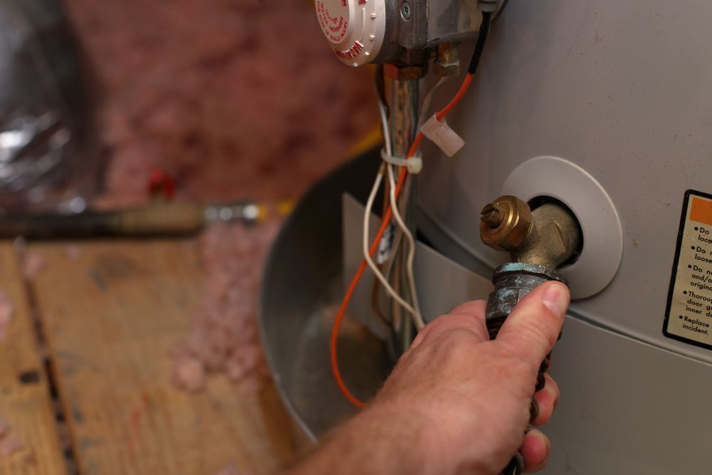 Hand Holding a Hose Connected to a Water Heater — Oxplumb in Coolum Beach, QLD