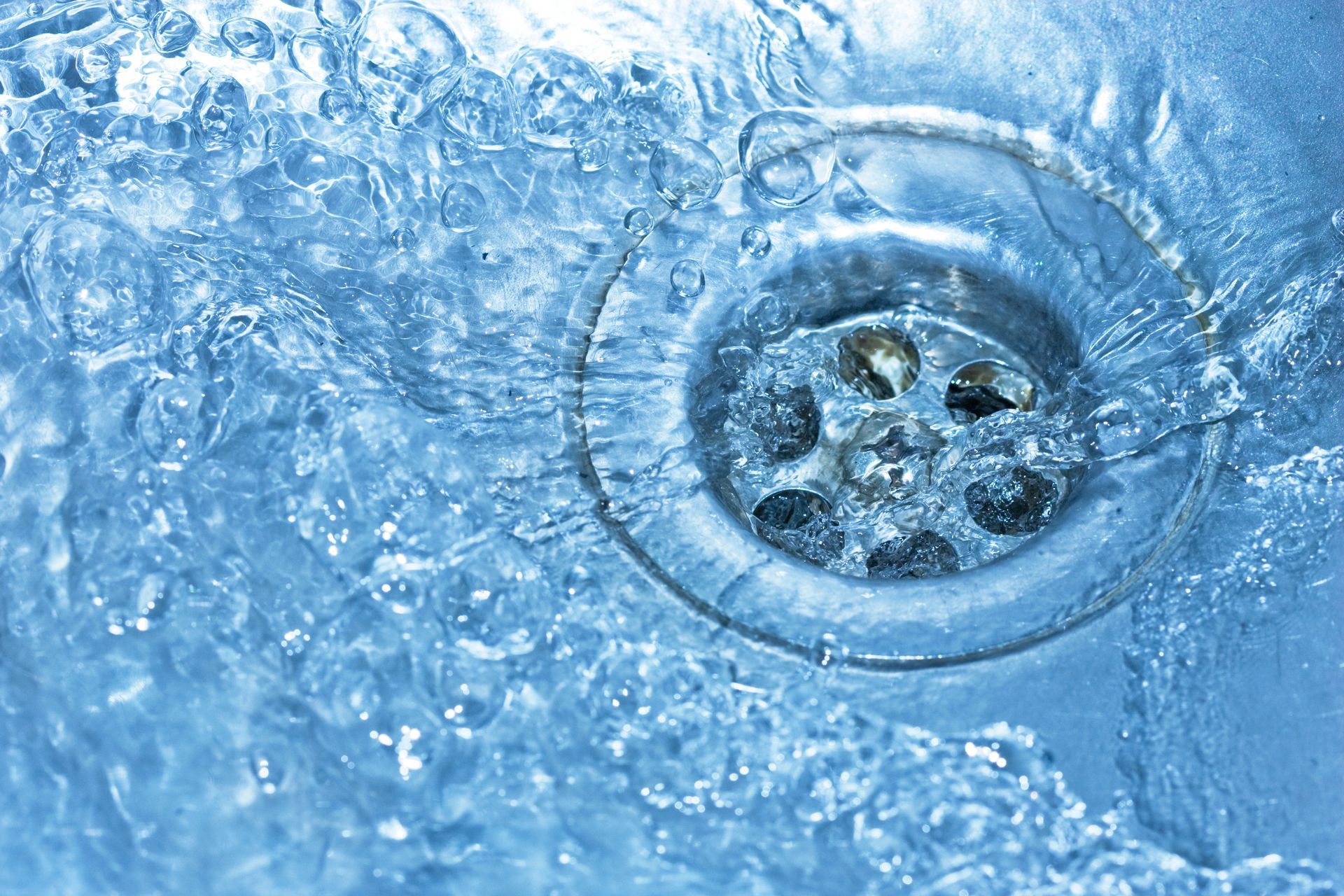 Water Swirling Down a Shiny, Metallic Sink Drain — Oxplumb in Caloundra, QLD