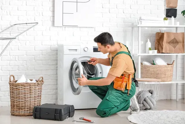 A Repair Technician Inspects the Inside of An Open Washing Machine — Central Coast Washing Machines & Refrigerator Repairs in Gosford, NSW
