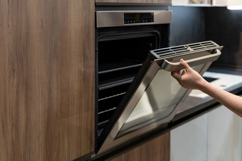 A Hand Opens the Door of a Modern, Stainless Stee — Central Coast Washing Machines & Refrigerator Repairs in San Remo, NSW