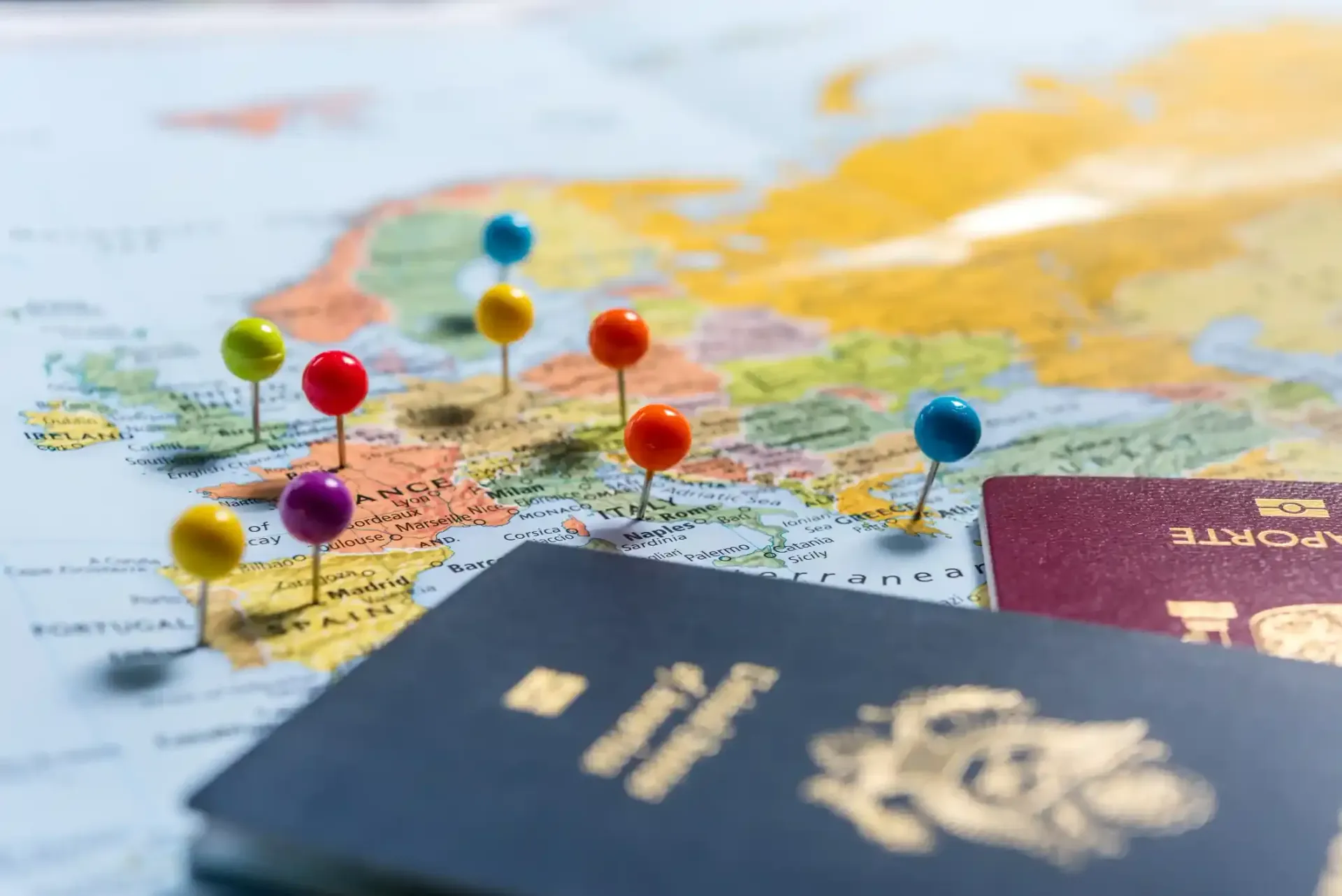 Map with colorful pins and two passports, ready for travel.