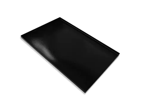 Libreta rectangular negra sobre superficie blanca, con bordes biselados. Tapa brillante con lomo encuadernado.