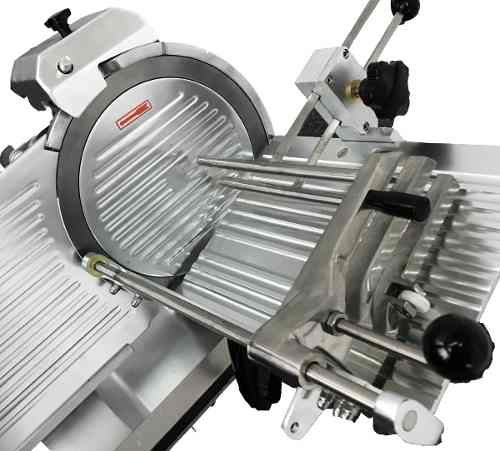 Rebanadora de carne comercial de acero inoxidable con cuchilla grande y bandeja angular. Montada sobre base con ruedas.