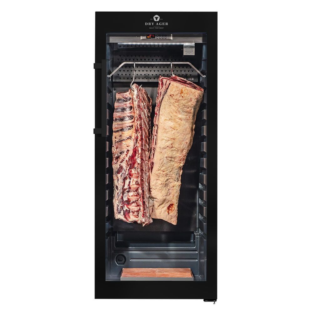 Refrigerador de maduración en seco de acero inoxidable con dos grandes cortes de carne colgados en su interior.