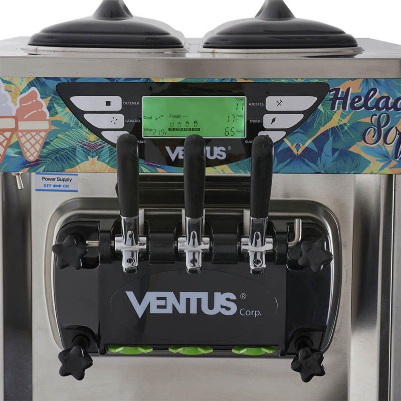 Máquina de helado suave de acero inoxidable con tres manijas dispensadoras sobre un carrito con ruedas.