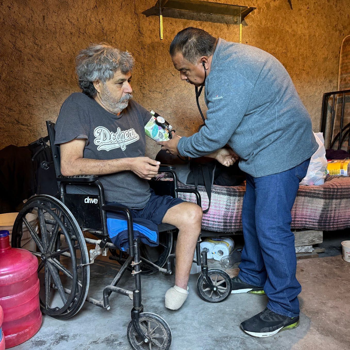 A man in a wheelchair is being examined by a doctor.