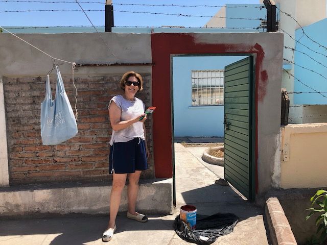 A woman is painting a wall with a brush