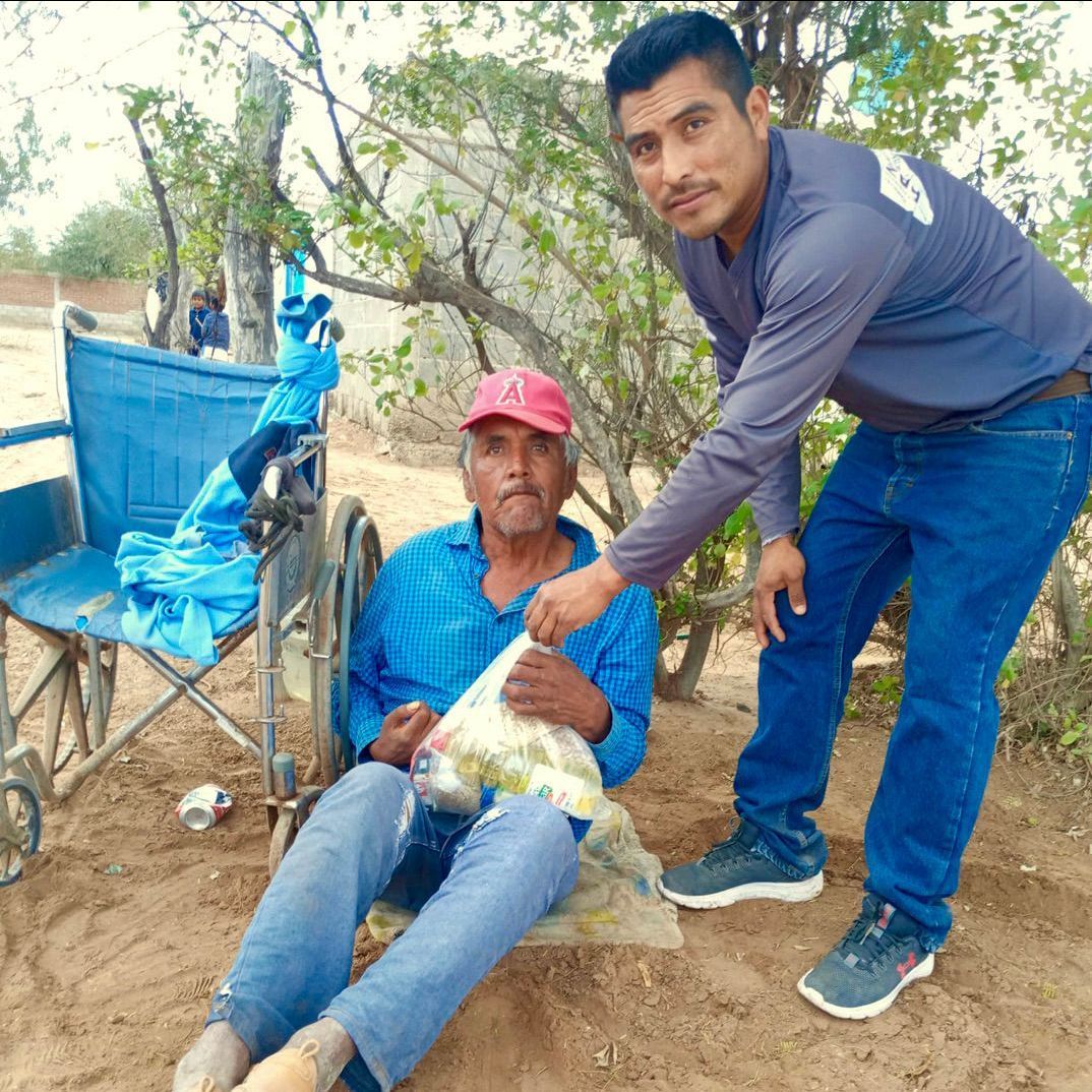 A man standing next to a man in a wheelchair