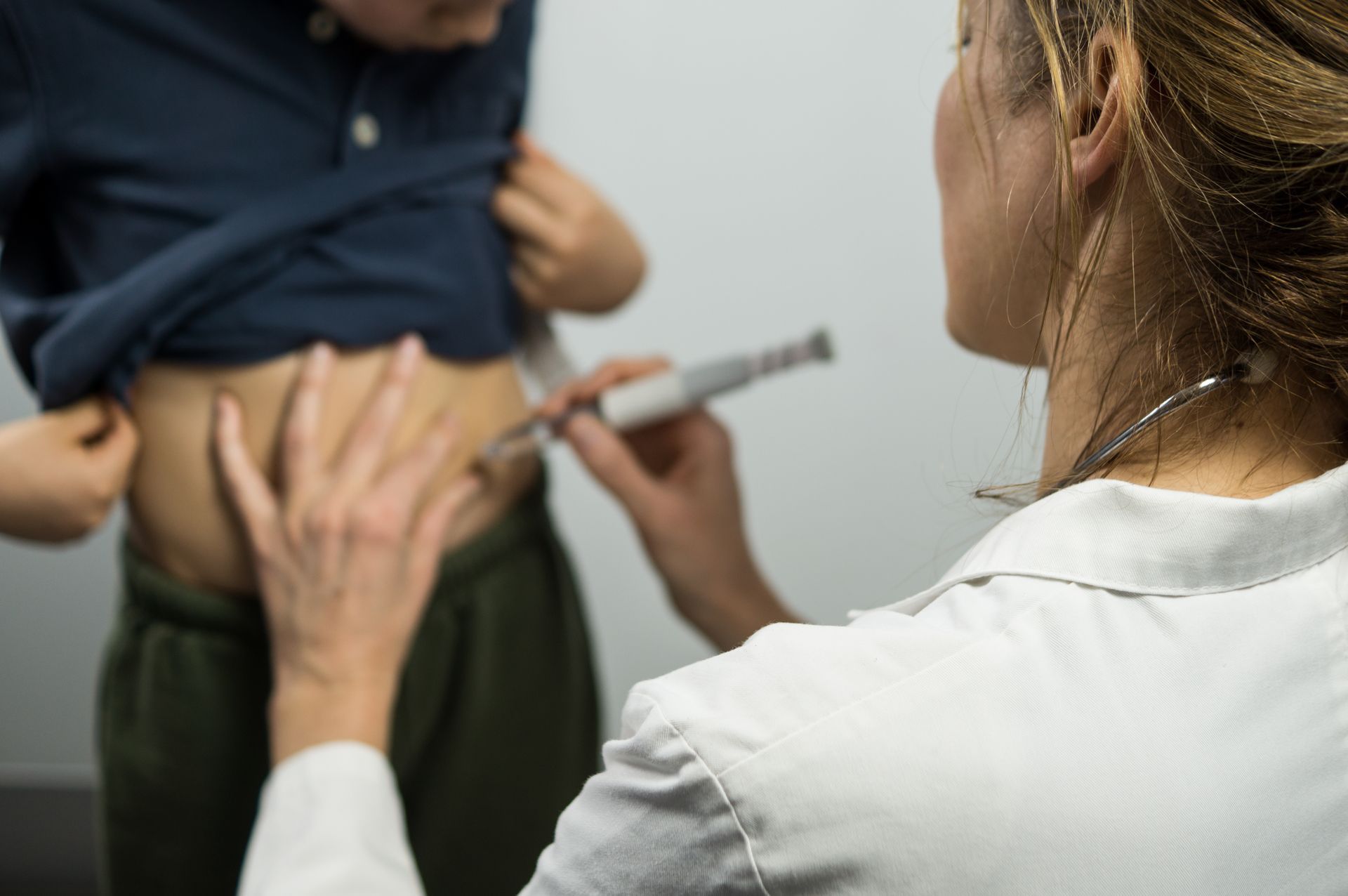 A doctor is giving a shot to a patient.