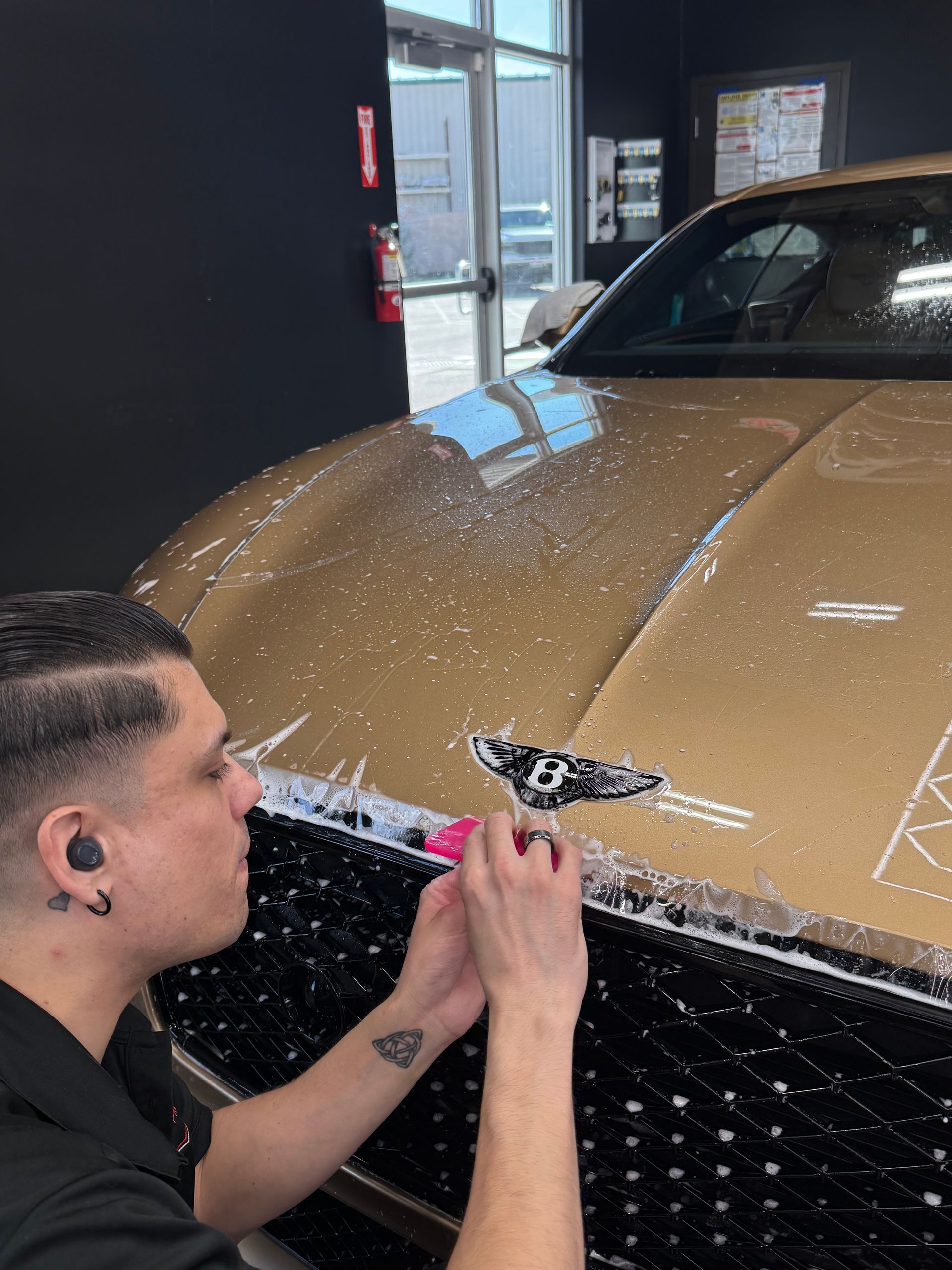Dynamic Auto Pros Technician installing Full Front PPF on a Gold Bentley Continental GT Speed luxury Car