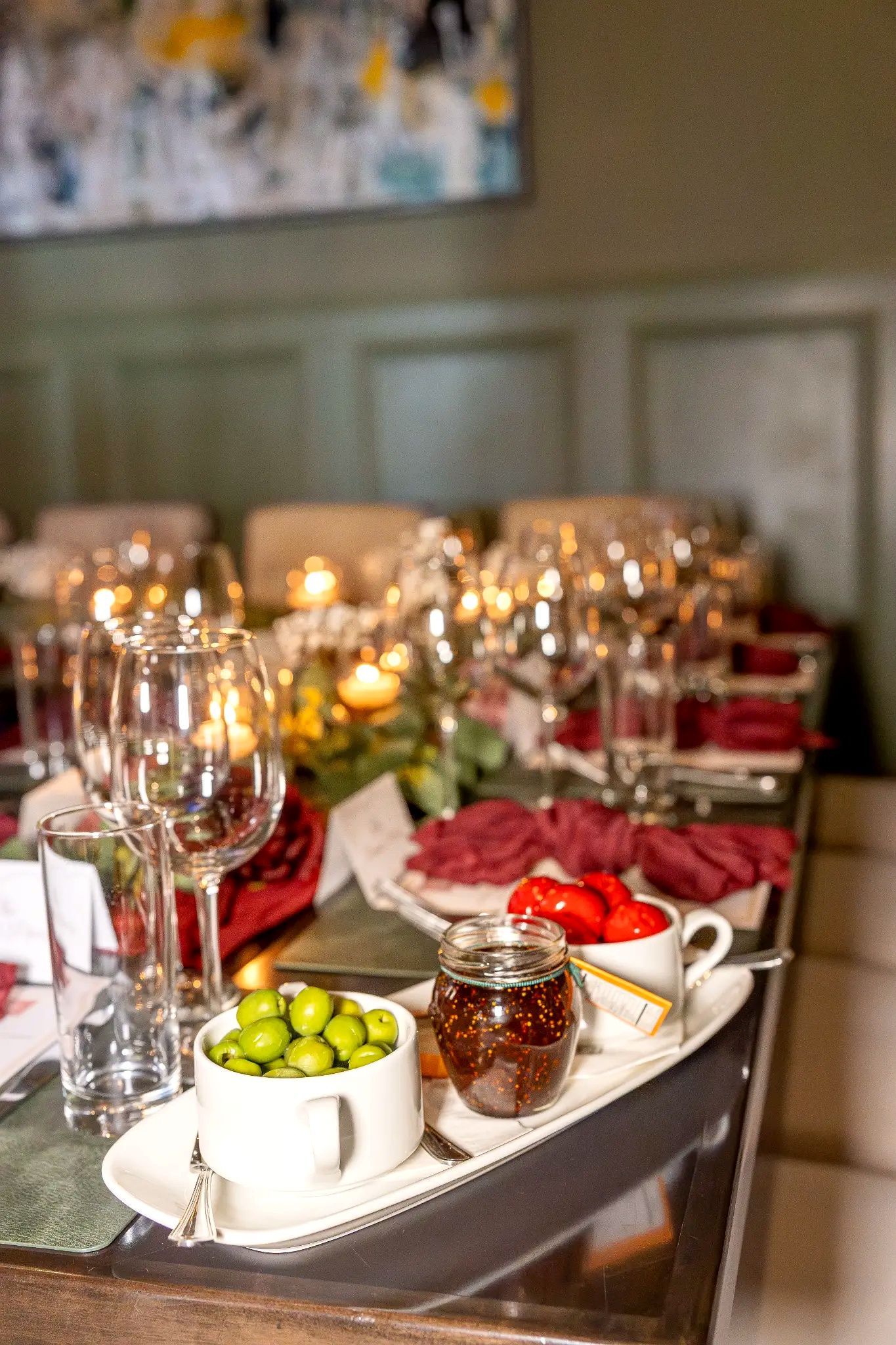 Elegant banquet table set with wine glasses, white napkins, and bowls of limes and olives