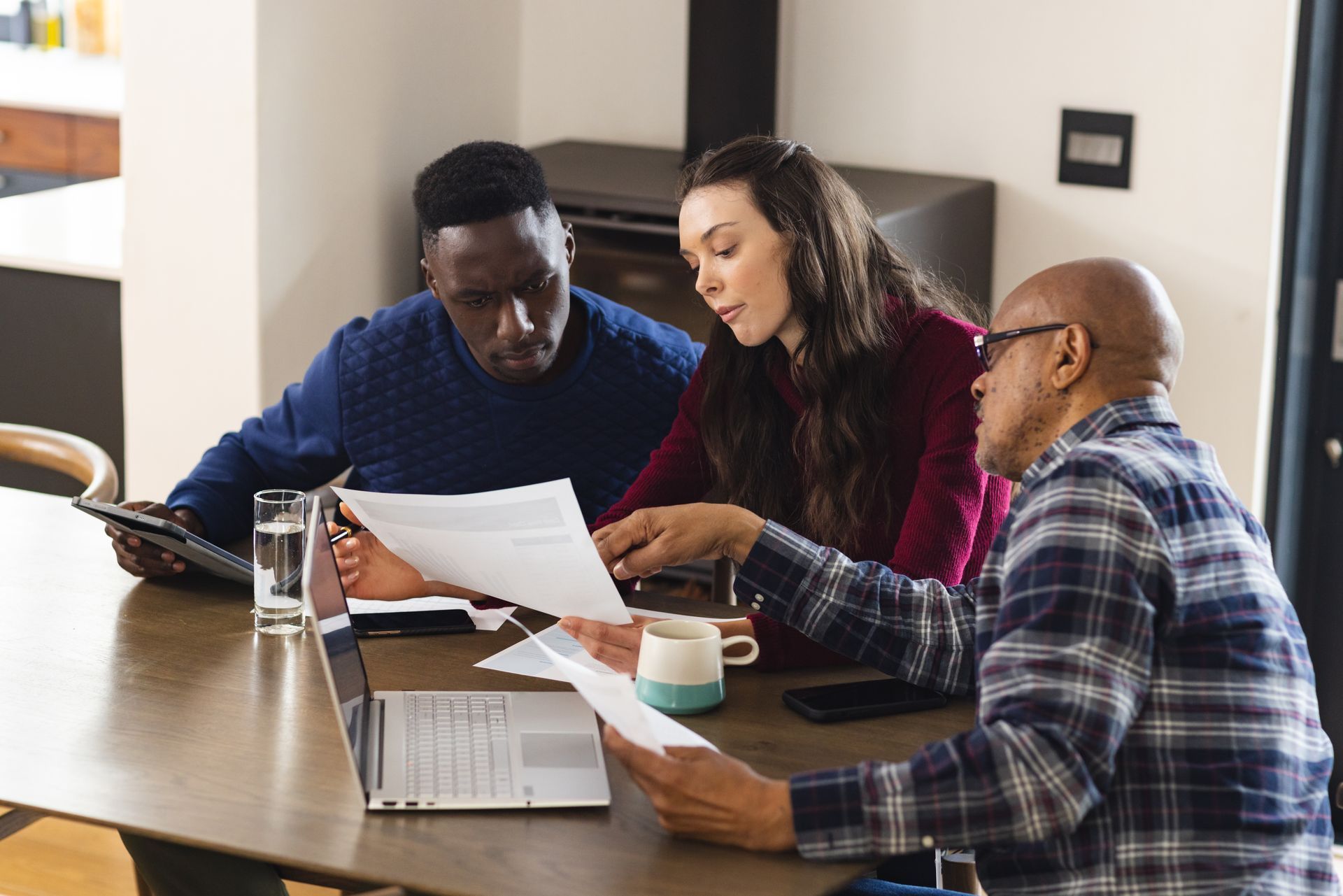 A group of people are sitting at a table looking at papers.