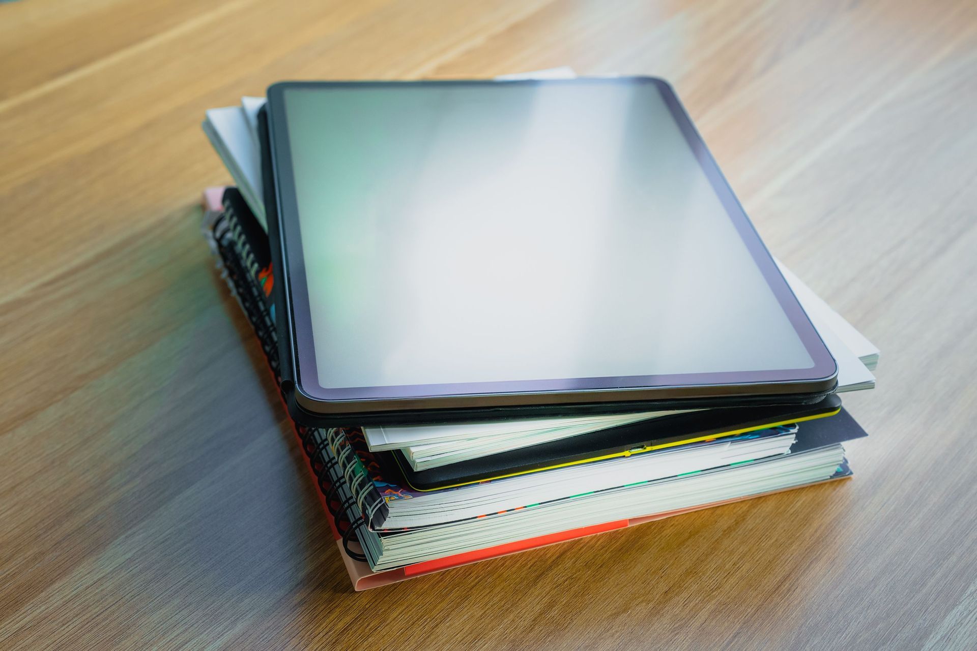 Stack of colorful notebooks on a wooden table
