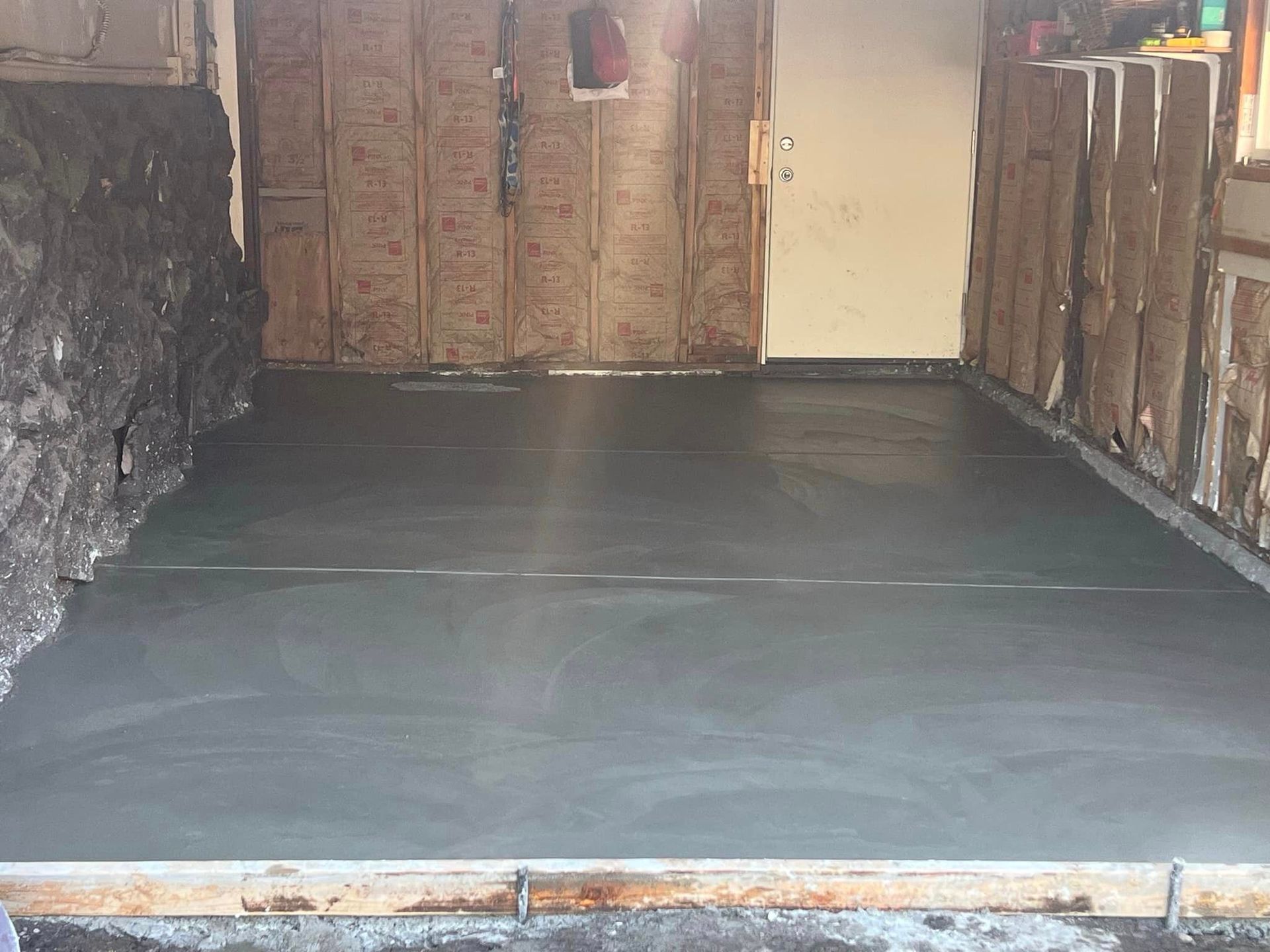 A concrete floor is being installed in a garage.