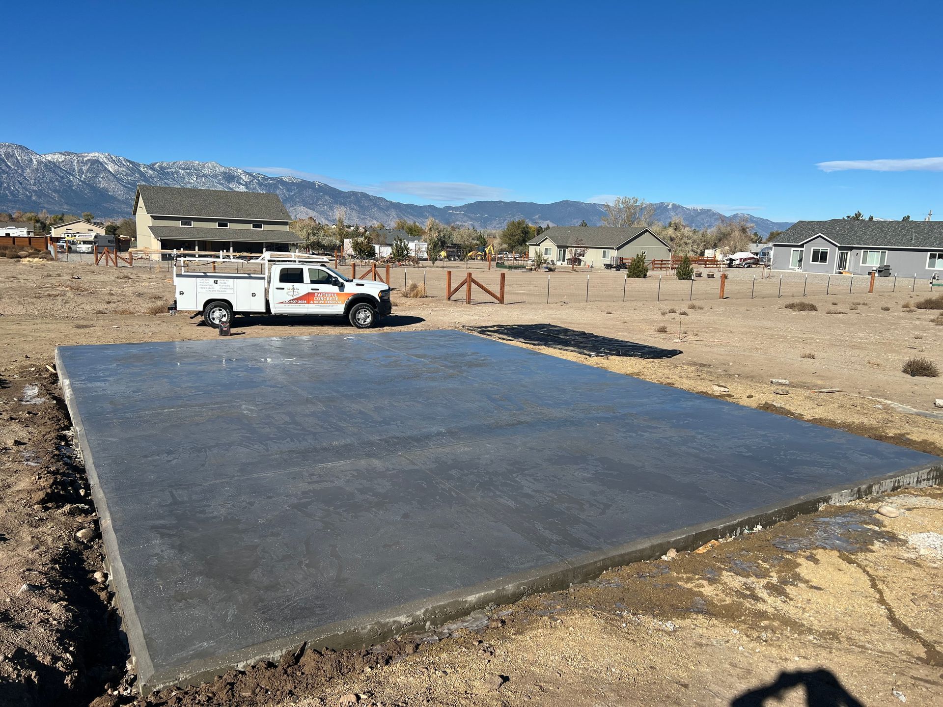 A concrete foundation is being built on a dirt field.