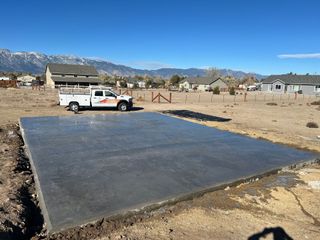 A house is being remodeled and a concrete foundation is being built in front of it.