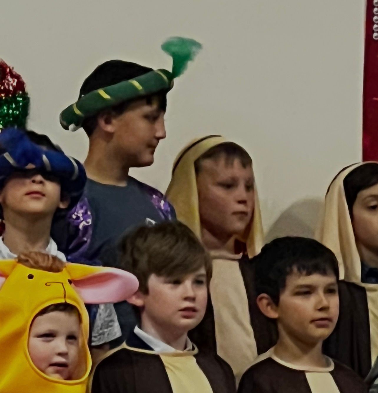 Children in costumes; some with head coverings, posing indoors.