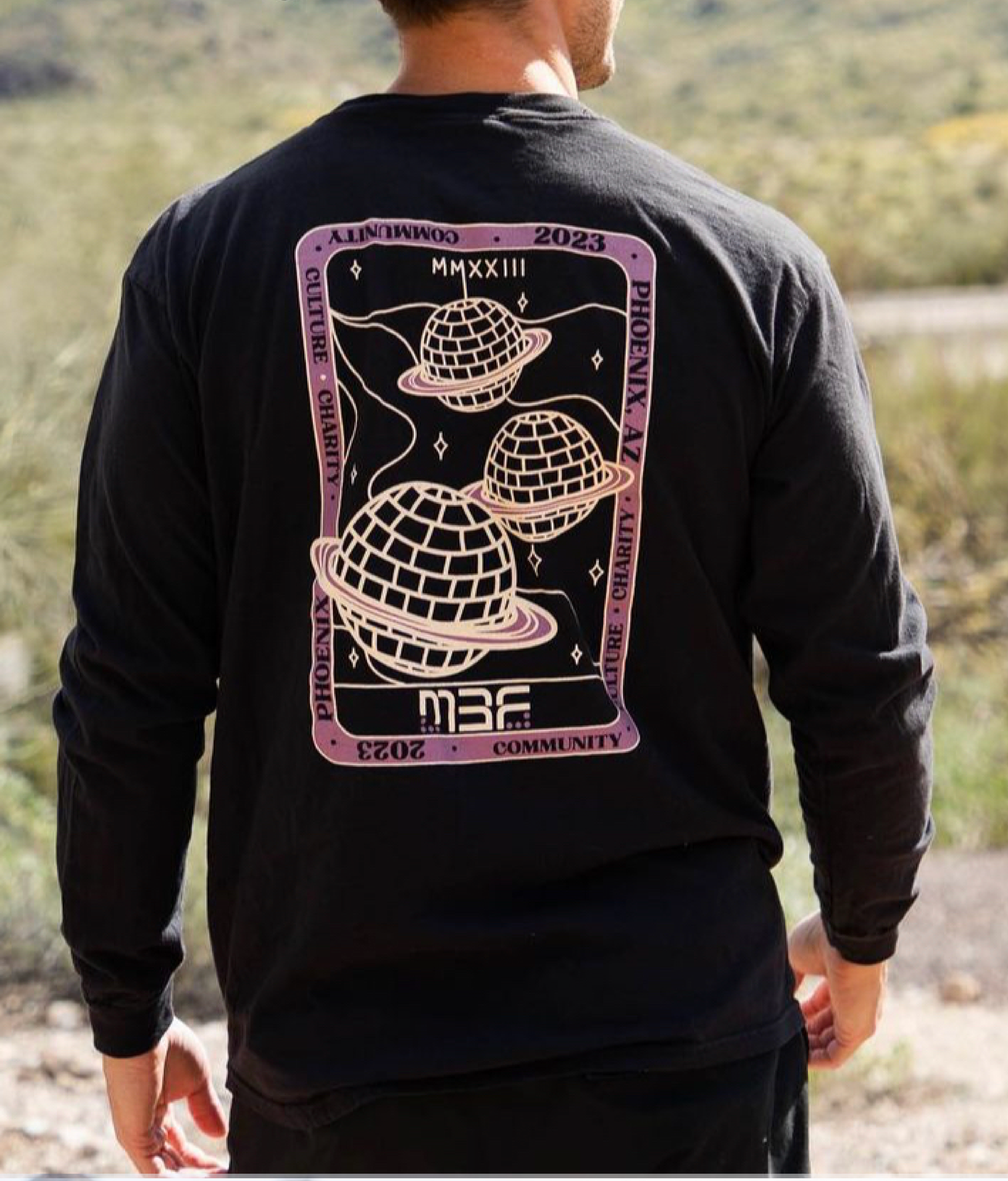 A man wearing a black shirt with planets on it