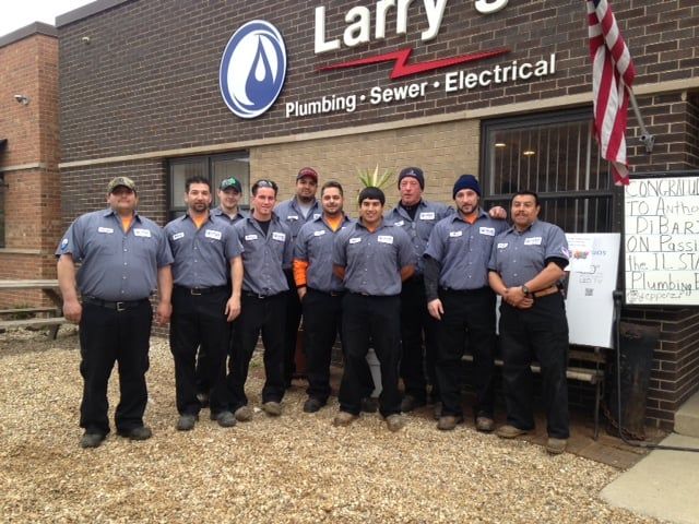 A group of men standing in front of a building that says larry