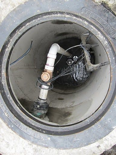 A manhole cover with a pipe coming out of it.