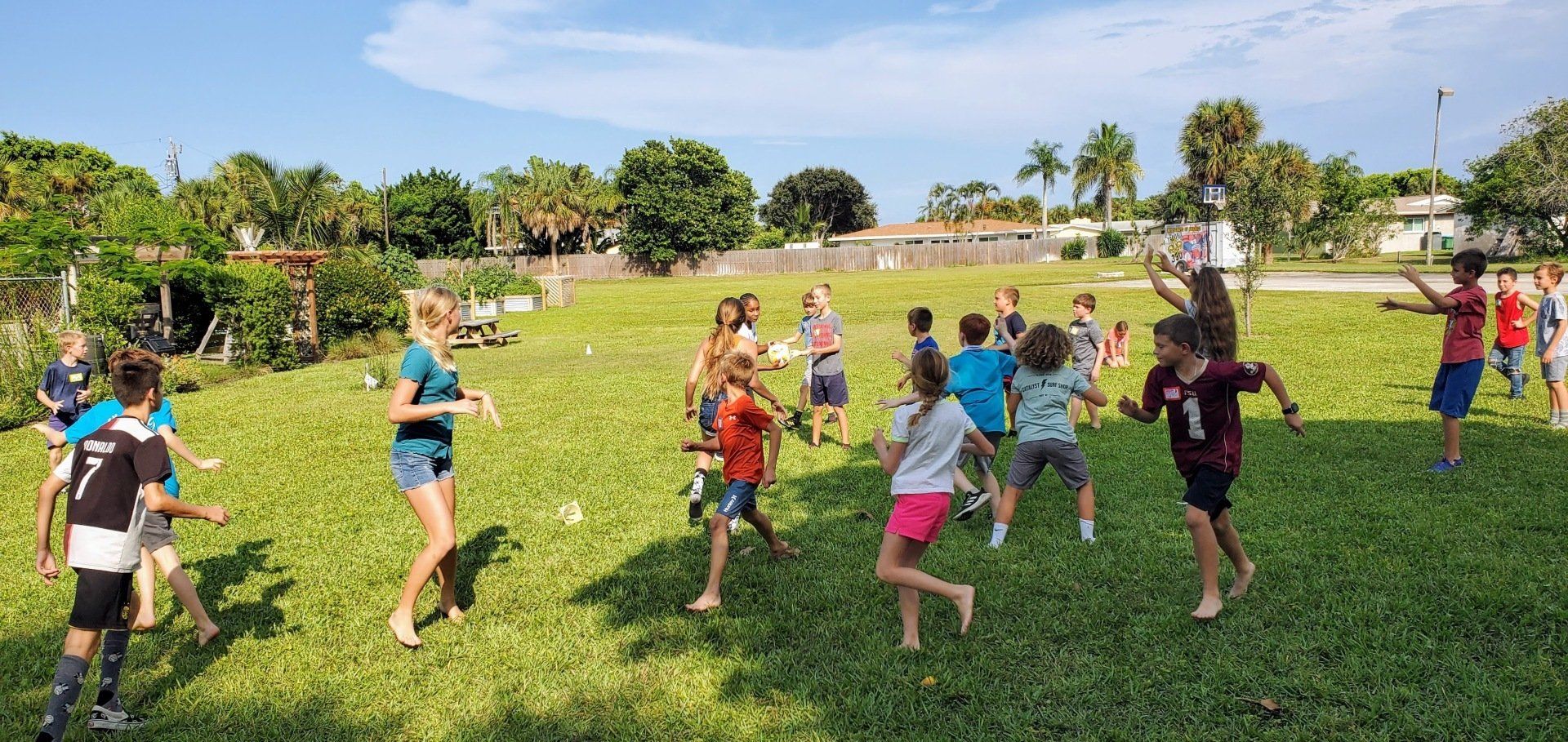 A group of children are playing in a grassy field.